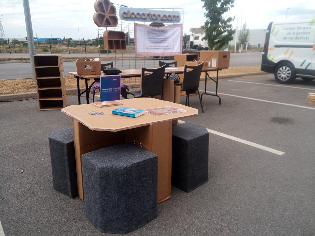 Une table en carton avec quatre poufs assortis. Exposition chez Evodia à Chavelot